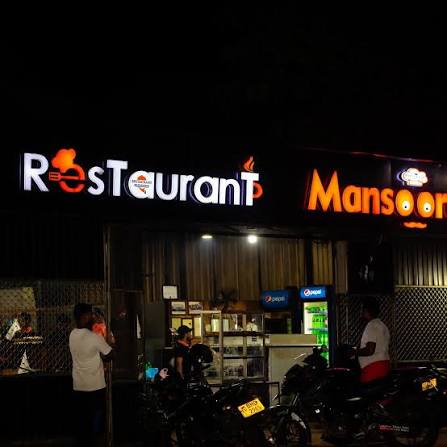 The Restaurant Mansoorah sign lit up at night on Colombo Road